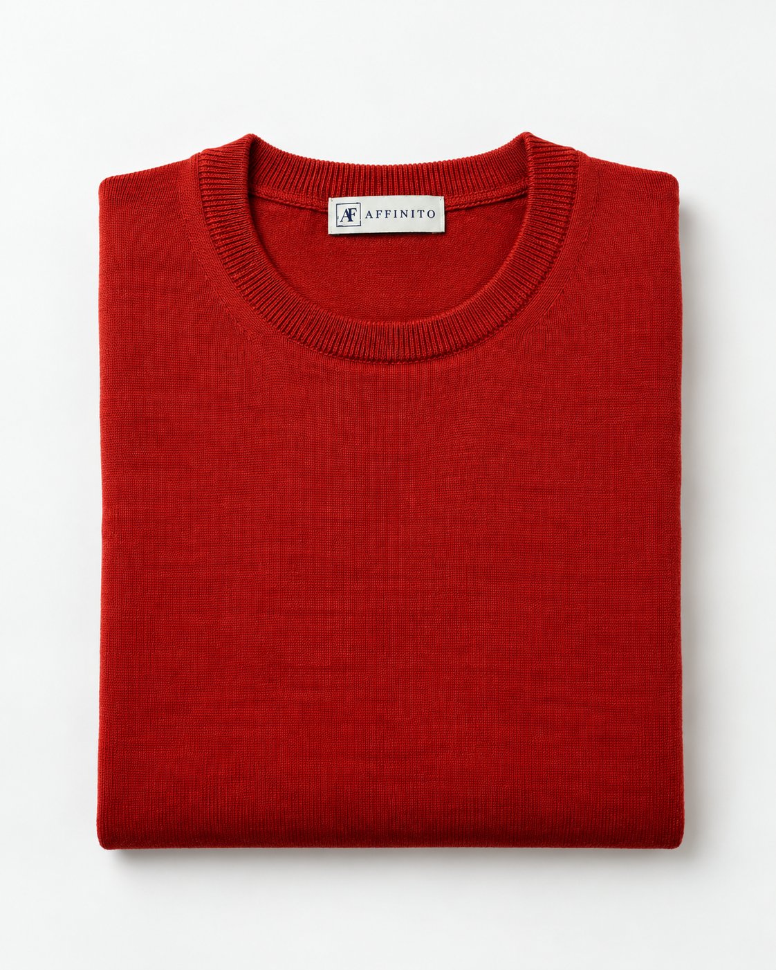 Maglia girocollo in lana merinos arancio Affinito, piegata su fondo bianco