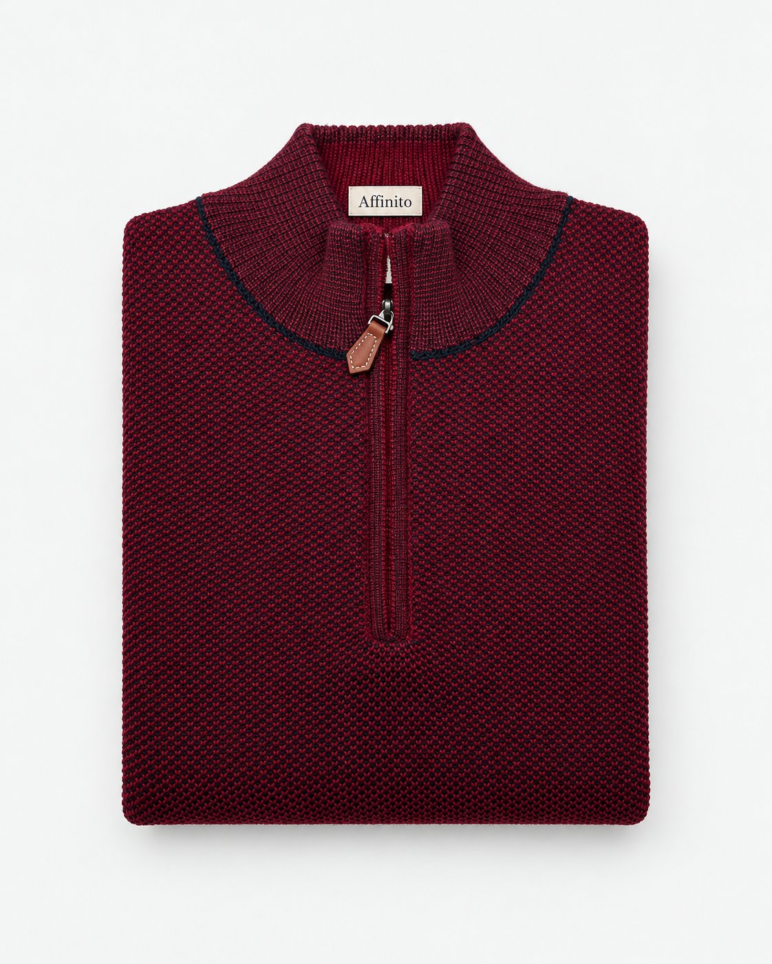 Maglia lupetto con mezza zip in punto riso bordeaux Affinito, profilo blu e tiretto in pelle, piegata su fondo bianco