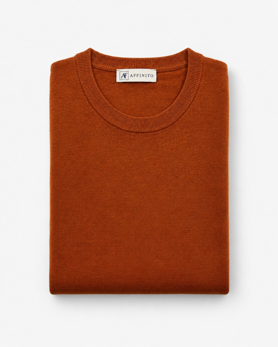 Maglia girocollo in maglia rasata arancio bruciato Affinito, piegata su fondo bianco