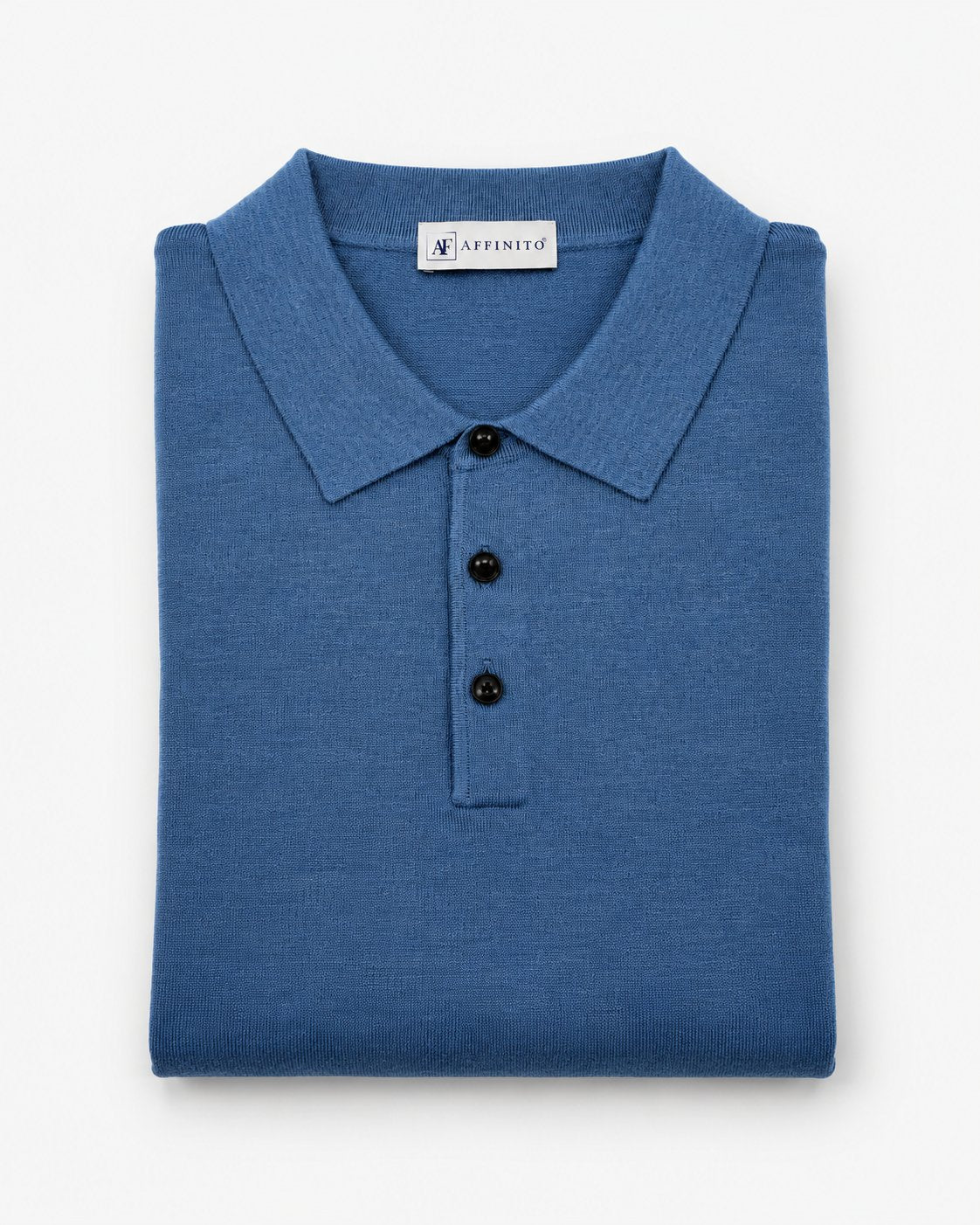 Polo in maglia rasata azzurra Affinito a manica lunga con tre bottoni, piegata su fondo bianco