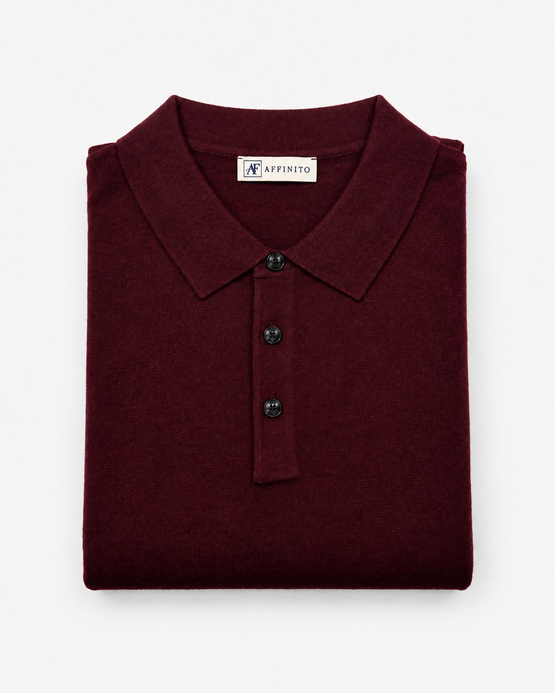 Polo in maglia rasata bordeaux Affinito a manica lunga con tre bottoni, piegata su fondo bianco
